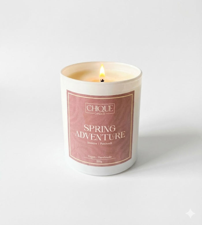 Candle with 'Spring Adventure' label on a white background