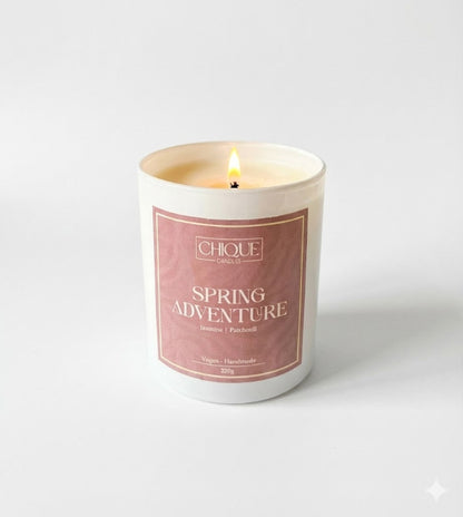 Candle with 'Spring Adventure' label on a white background